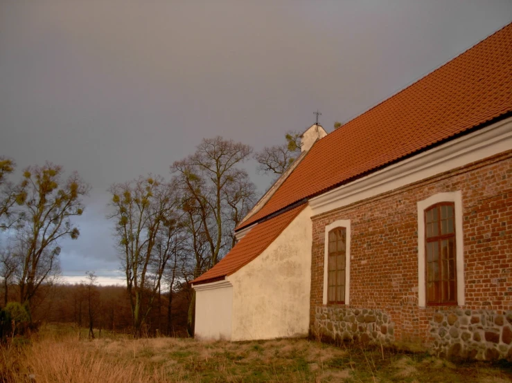 a large brick house with a red tiled roof