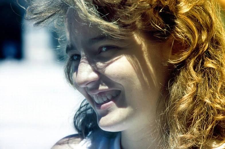 a woman smiling at soing with long red hair