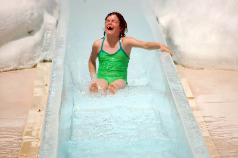 the lady is enjoying her waterslide at the pool