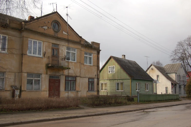 old house in city, next to road in winter