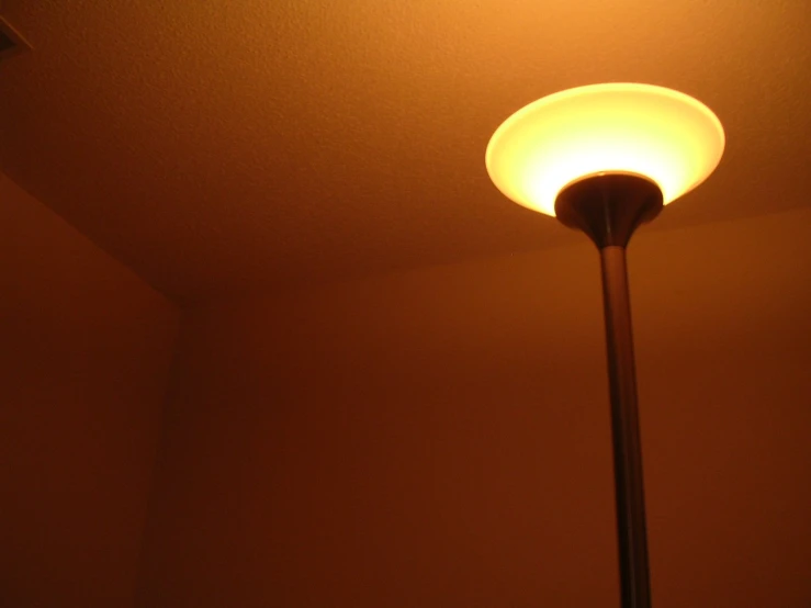 a lamp lit by two yellow lights on a white wall