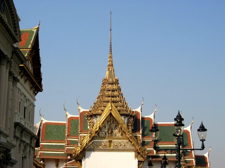 ornate golden and green building with street lamps in foreground