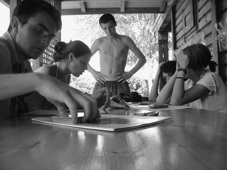 four shirtless guys and two girls working on crafts