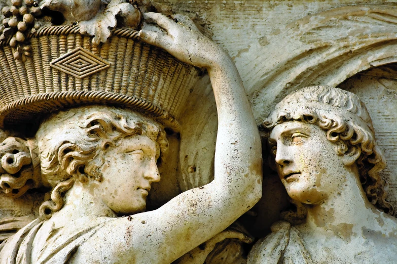 some sculptures of women holding baskets in front of a building