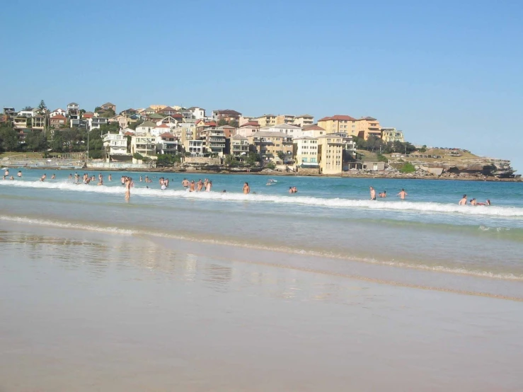 a beach filled with people swimming on top of it