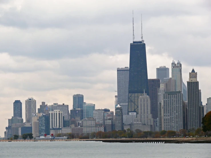 a boat sails through the water with a huge city in the background