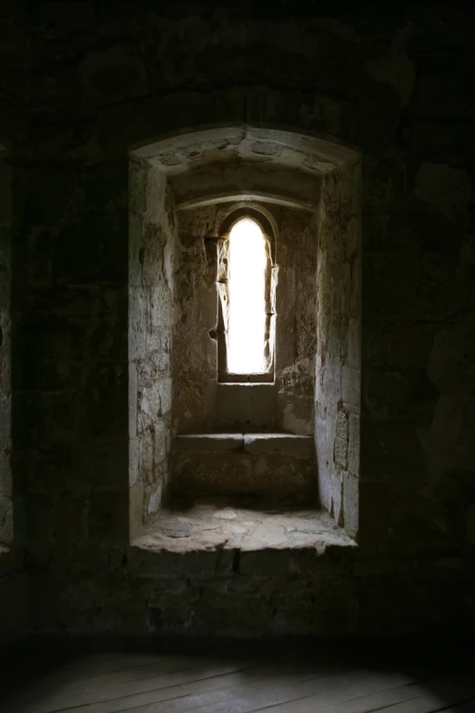 an empty stone room with a window in it