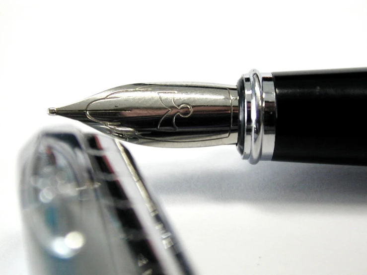 a fountain pen resting on top of a white surface