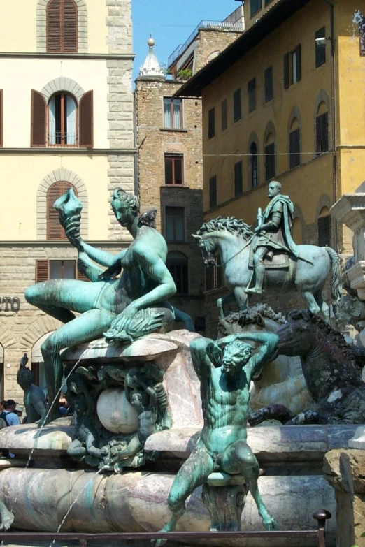 a fountain with statues of men, horses and other people