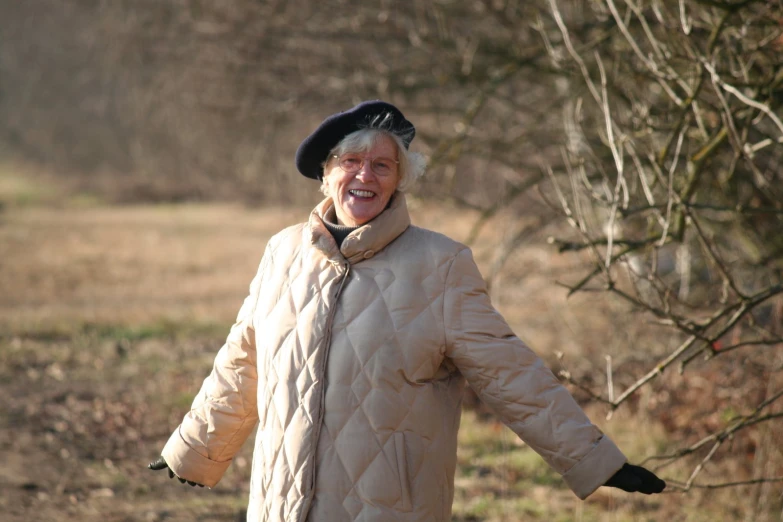 a woman dressed in warm clothes and a black hat smiles for the camera