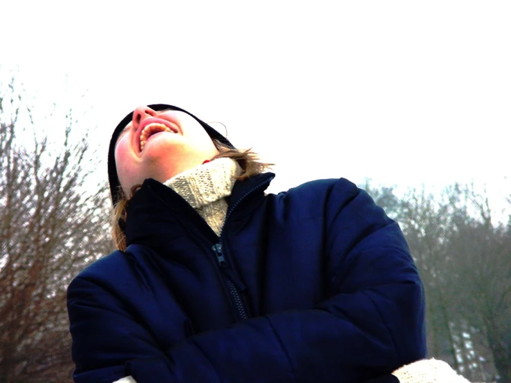 a woman is outside in the snow with her eyes closed