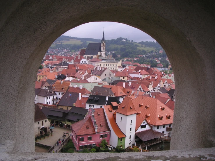 red roofs sit below a large stone arch in an old town