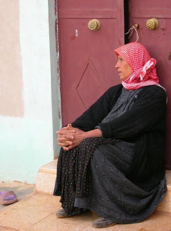 a woman in a black outfit is sitting on the step