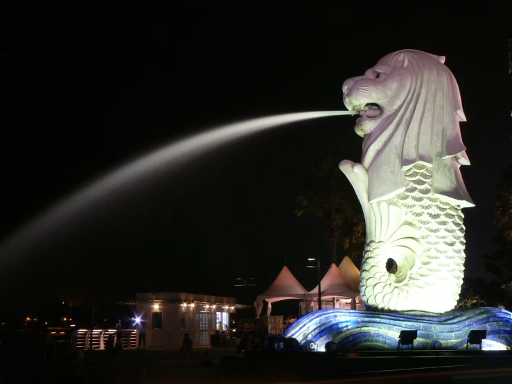 a big water fountain spewing water onto a fish statue