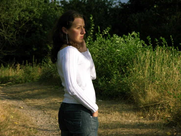 a beautiful young lady standing in the middle of a road