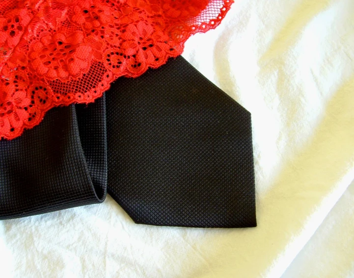 black tie with lace and red fabric on white background