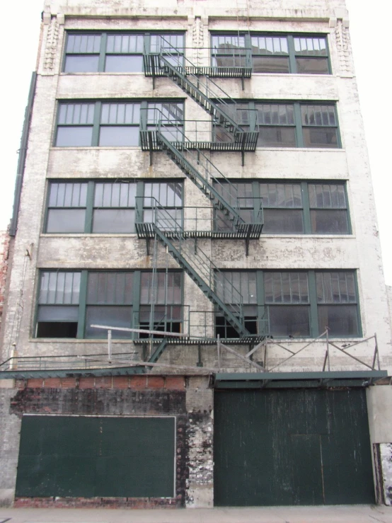 a parking lot has two fire escapes with a garage below