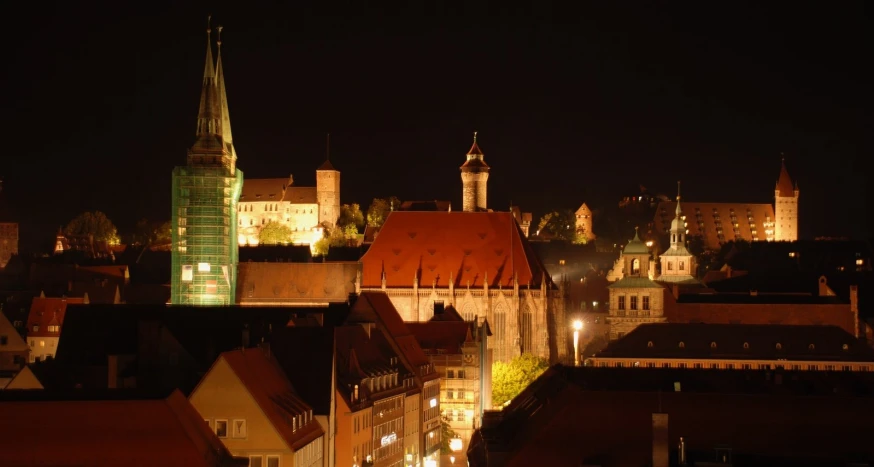 the buildings are lit up and all have a large tower