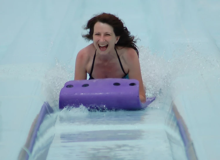 a woman is on the water board in the pool