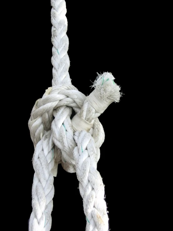 a white rope knot that is wrapped around a pole