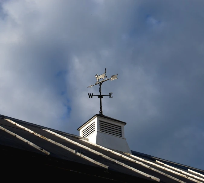 a wind vane on the roof of a house