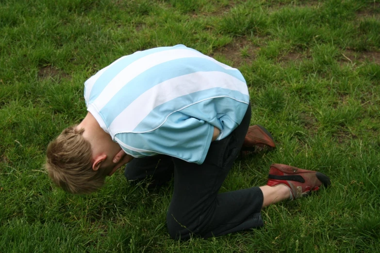 a  dressed in a blue and white  shirt is on the grass