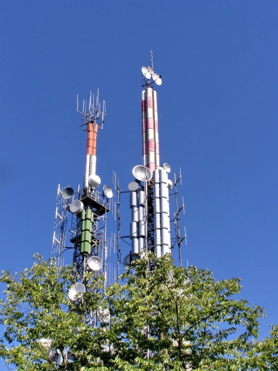 two tall cellular towers with multiple antennas above them