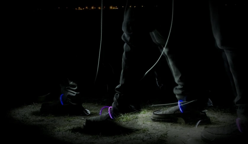 two people are standing next to each other while lights shine on the shoes