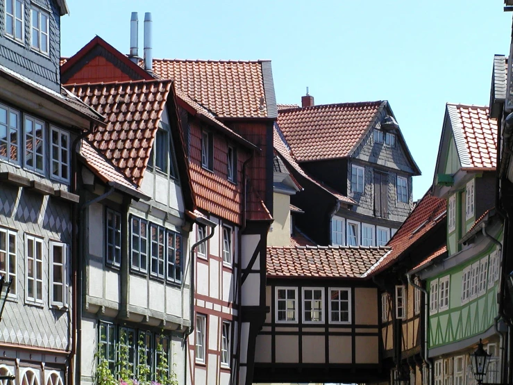 some buildings with green and brown trim and red roof tiles