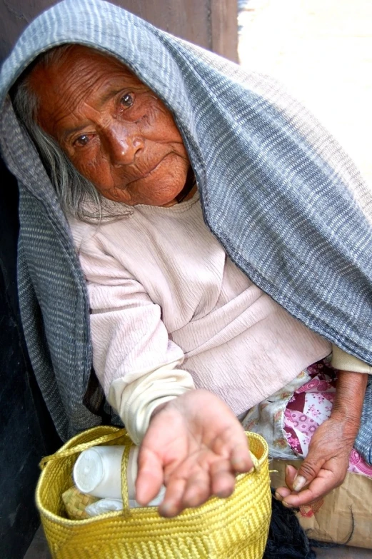 an old woman is holding her yellow basket