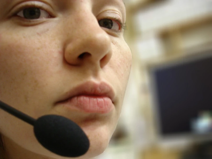 the woman is wearing a headset to the computer