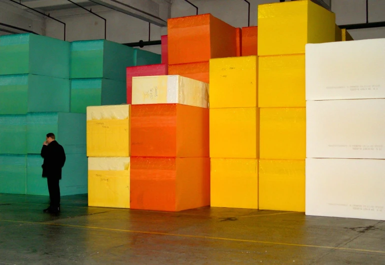 the man is standing in front of some large boxes