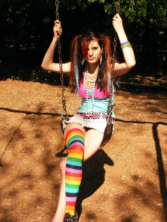 a woman sitting on a swing wearing bright colored tights