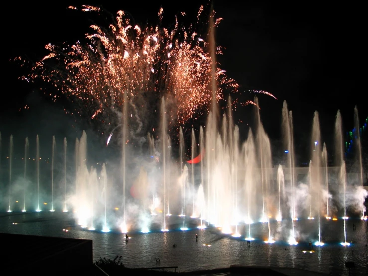 a very big pretty firework with a big clock tower in the back ground