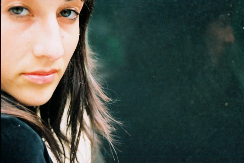 a close up view of the face of a woman in front of a window