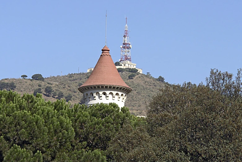 a castle tower sitting on top of a lush green hillside