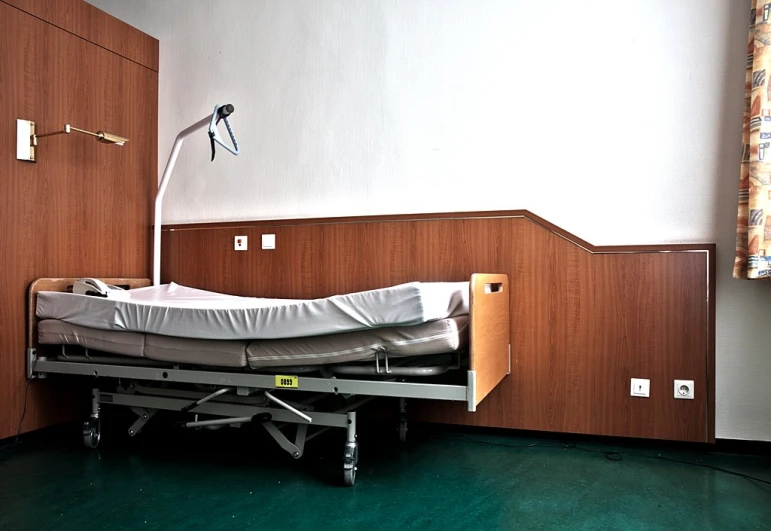 a room with a bed and a sink with wood cabinets