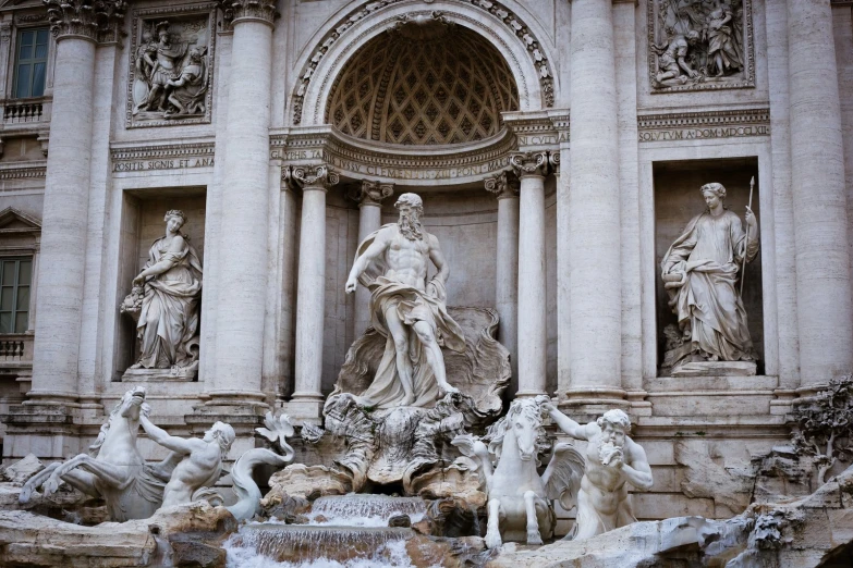 statues of different ages are in front of a water fountain