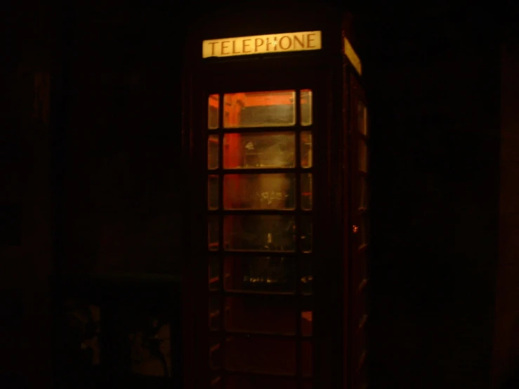 the telephone booth is lit up at night