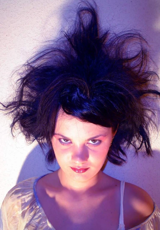 a woman with a messy hair sitting down