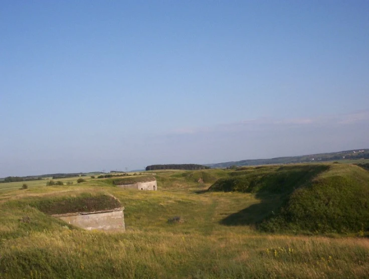 there is an old building that is on the grassy hill