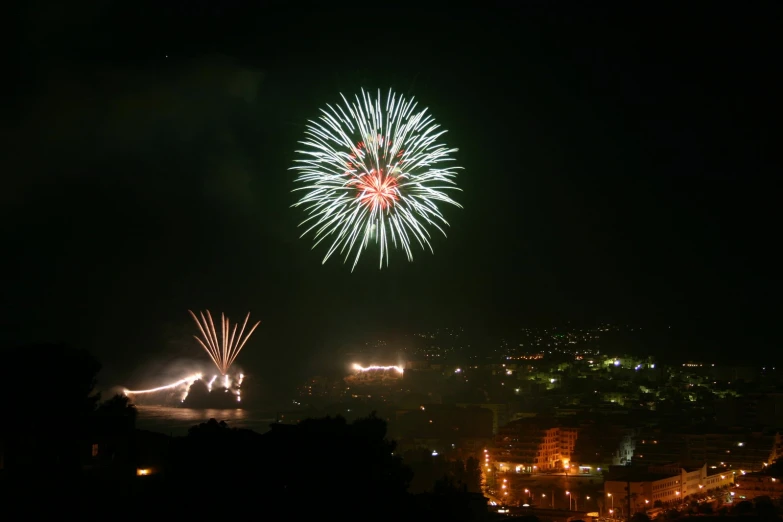 fireworks go off in the sky above some buildings