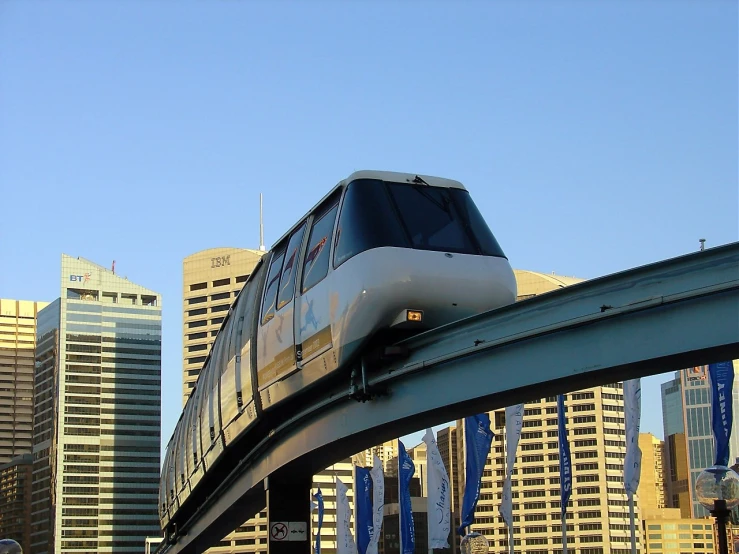 a white passenger train on the tracks over a bridge