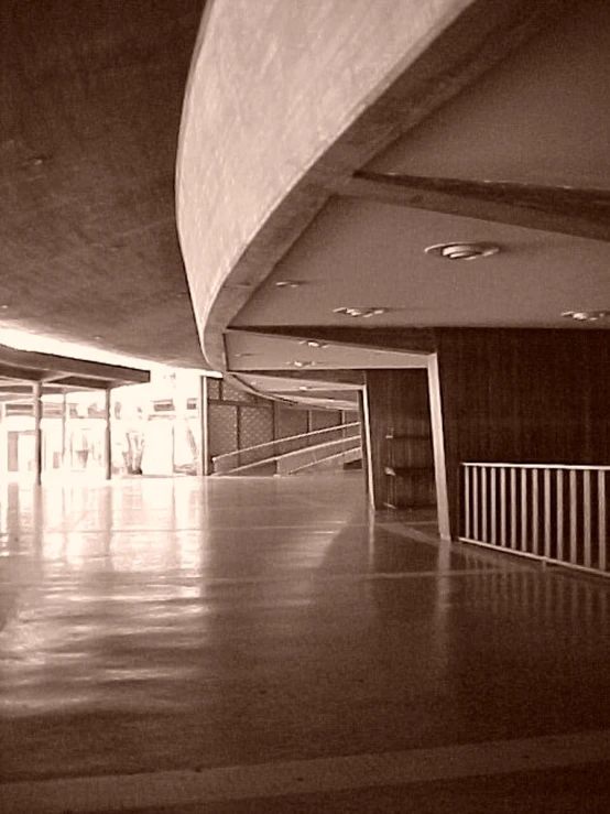 a hallway leading to a very long room with a ceiling and floor to ceiling windows