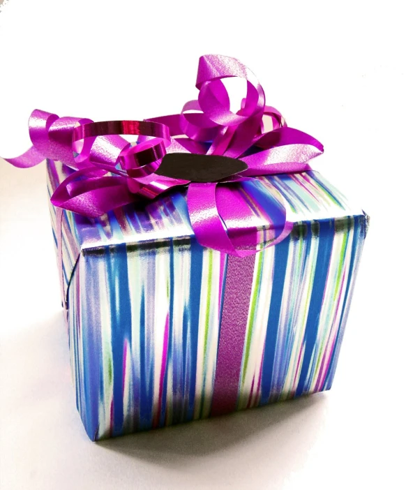 a gift box that has been wrapped with purple ribbon