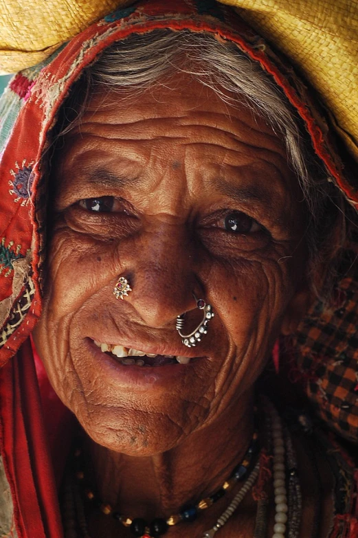 an older woman with a large smile wearing beads