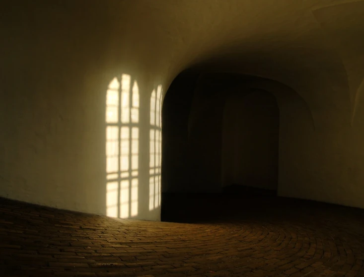 bright window shining in between two white walls in a dimly lit building