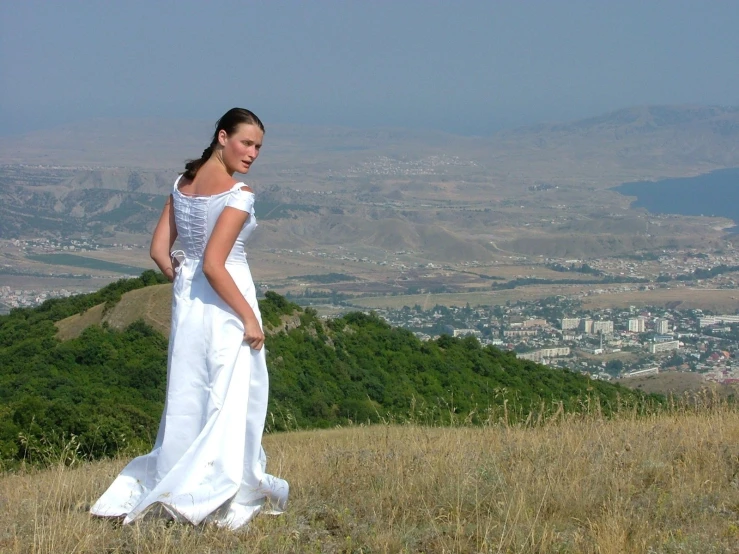 a woman is in white walking in a field