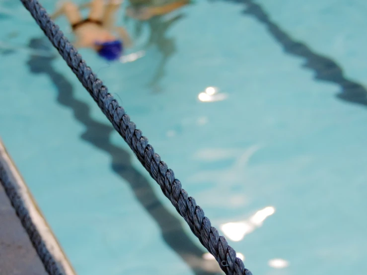 a pool filled with blue water and a black rope