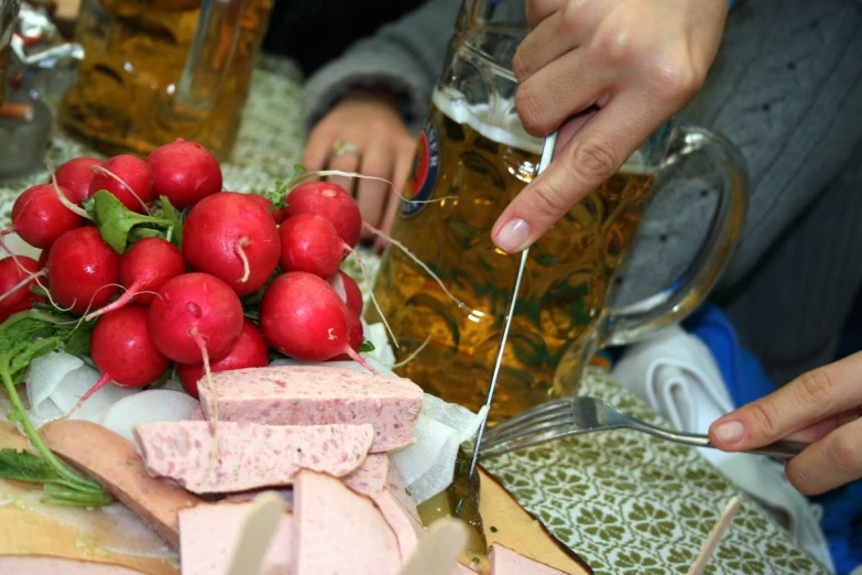 people are eating and drinking at a table with food items